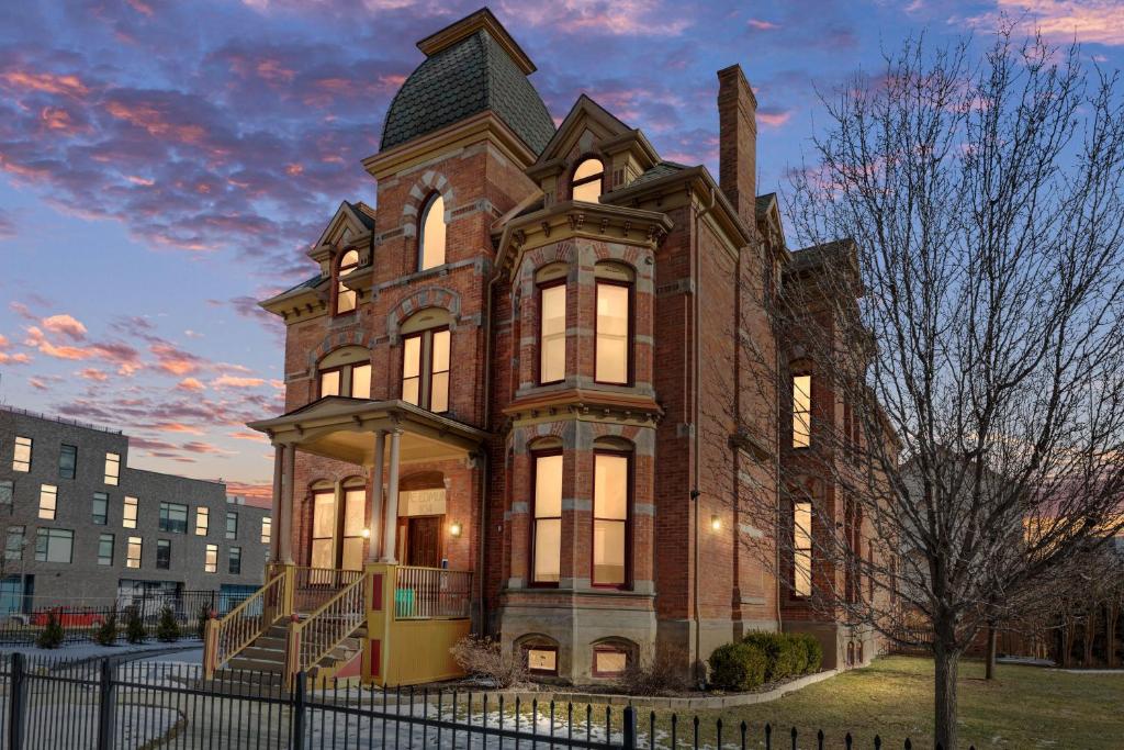 底特律The Lumber Baron's Mansion: 2 King Suites, 2.5BA + Gym的一座带塔楼的大型砖砌建筑