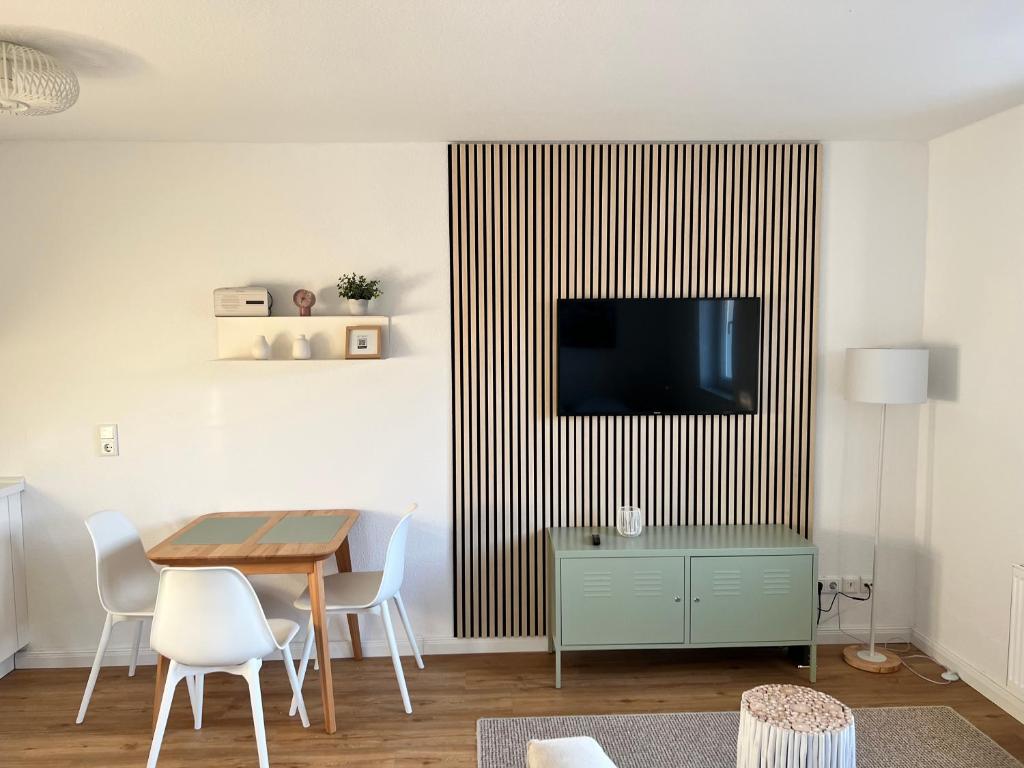 维斯马Smultron Apartment Altstadt Wismar的客厅配有桌子和墙上的电视