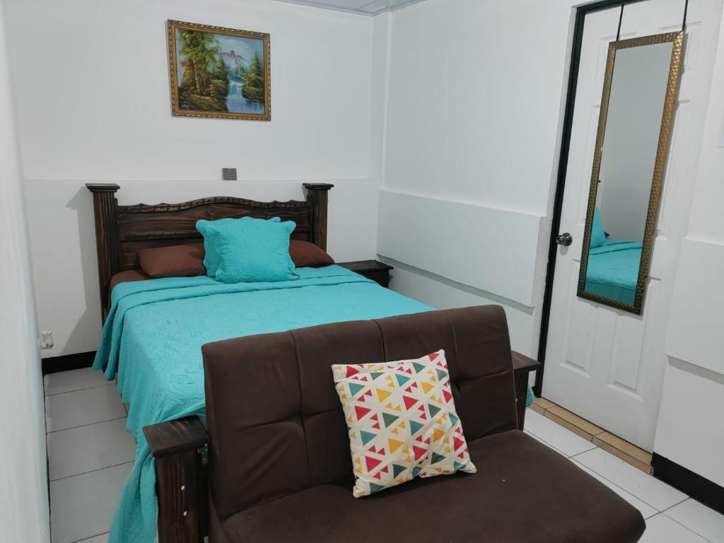 DesamparadosGran Hotel Desamparados的一间卧室配有一张床、一张沙发和一面镜子
