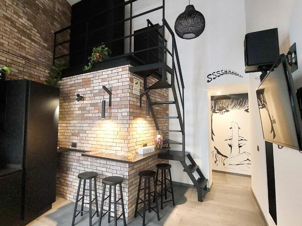 巴勒莫Sant'Andrea - Luxury Rooms in Vucciria的一间设有砖砌壁炉的房间,四周设有凳子