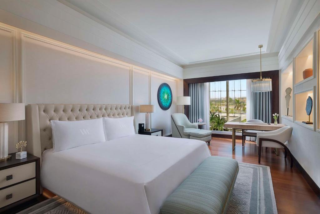 开罗Waldorf Astoria Cairo Heliopolis的卧室配有一张白色大床和一张书桌