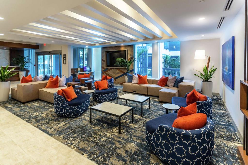 西棕榈滩Hilton Garden Inn West Palm Beach I95 Outlets的带沙发和桌子的客厅以及窗户。
