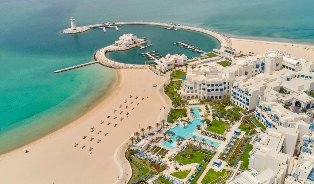Hilton Salwa Beach Resort and Villas的享有海滩的空中景色,设有建筑和海洋