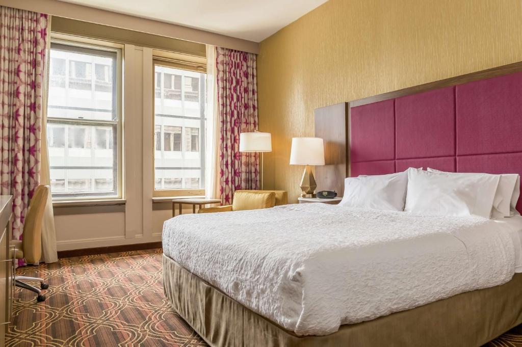 芝加哥美琪芝加哥剧院区汉普顿酒店的酒店客房设有一张大床和一个紫色床头板