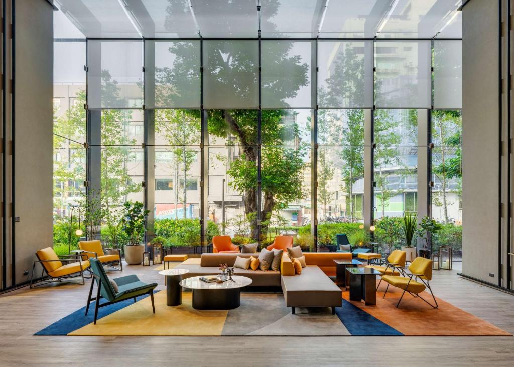 台北台北时代寓所-希尔顿启缤精选酒店的大堂配有沙发、椅子和窗户。