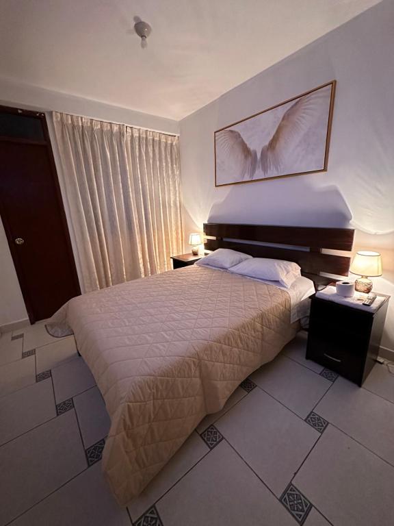 安达韦拉斯LUX - HOTEL BOUTIQUE的一间卧室配有一张床、两盏灯和一个窗户。
