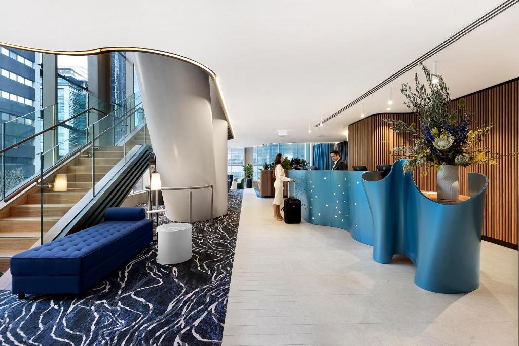 悉尼Citadines Walker North Sydney的拥有蓝色墙壁和楼梯的办公大厅