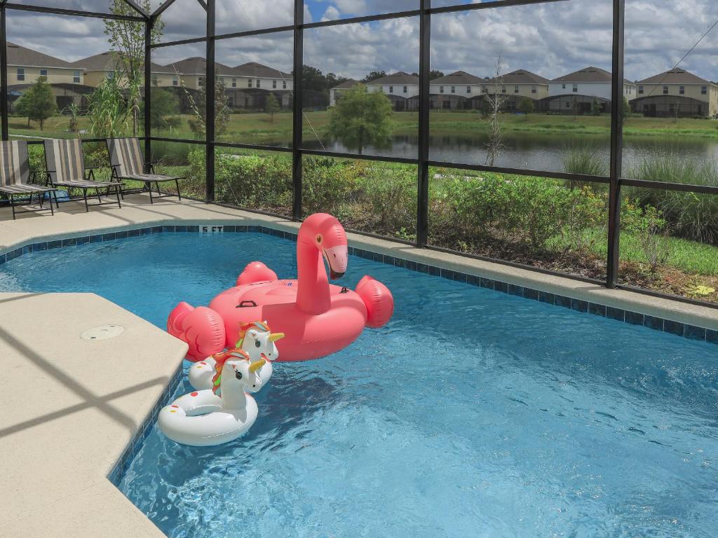 基西米Waterfront Brand New Modern Luxury 8 BR pool house! Sleeps 16的水中一个粉红色充气面的小泳池
