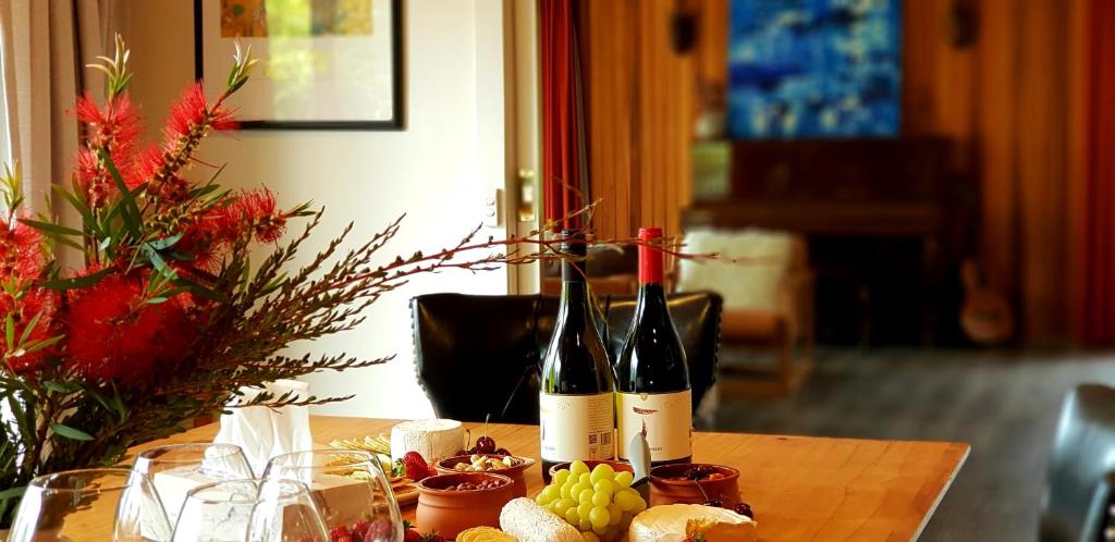 霍巴特霍巴特入口度假屋的两瓶葡萄酒坐在带葡萄的桌子上