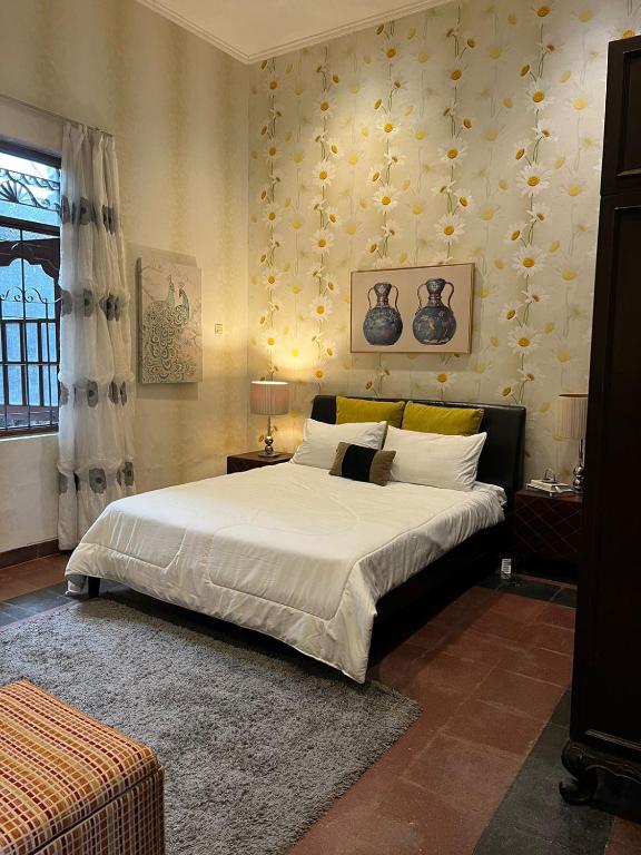 雅加达SOETJIPTO HOME STAY VILLA的一间卧室配有一张带白色床单的大床