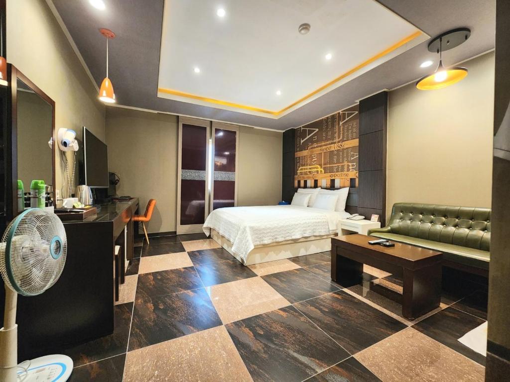蔚山Hotel Kobos的酒店客房,配有床和沙发
