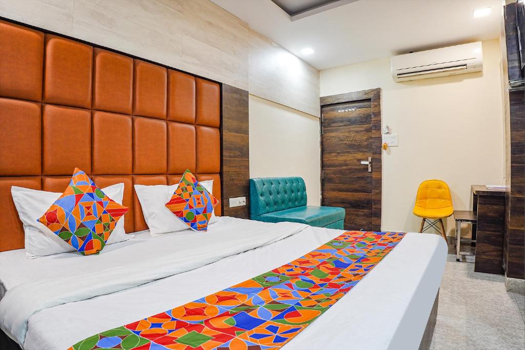 NaiāpuraFabHotel Brij Residency的配有一张床和一把椅子的酒店客房