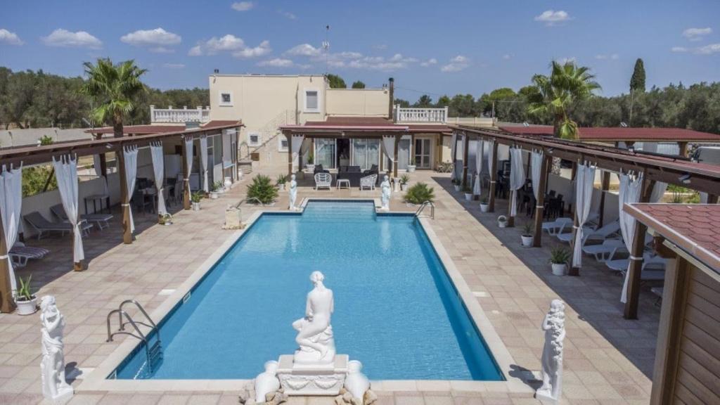 奥里亚Villa Jany- Adults only的一座建筑中间的一座带雕像的游泳池
