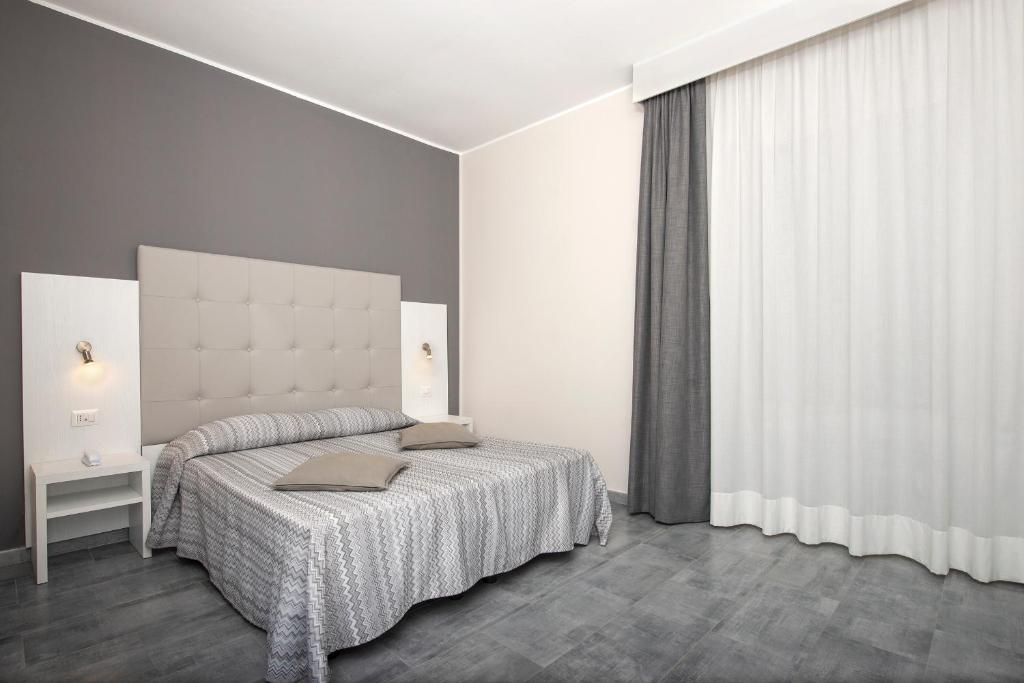 热那亚阿萨罗堤酒店的一间卧室设有一张床和一个大窗户