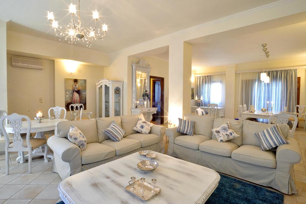 Ágios Ioánnis美丽达别墅的带沙发的客厅和用餐室