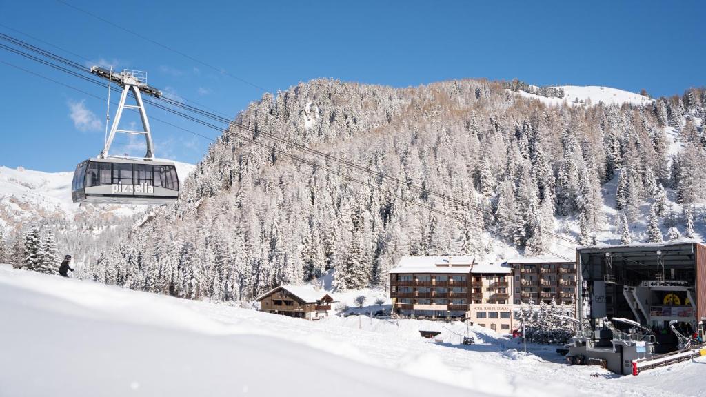 塞尔瓦迪加尔代纳山谷Hotel Plan De Gralba - Feel the Dolomites的雪覆盖的山前的滑雪缆车