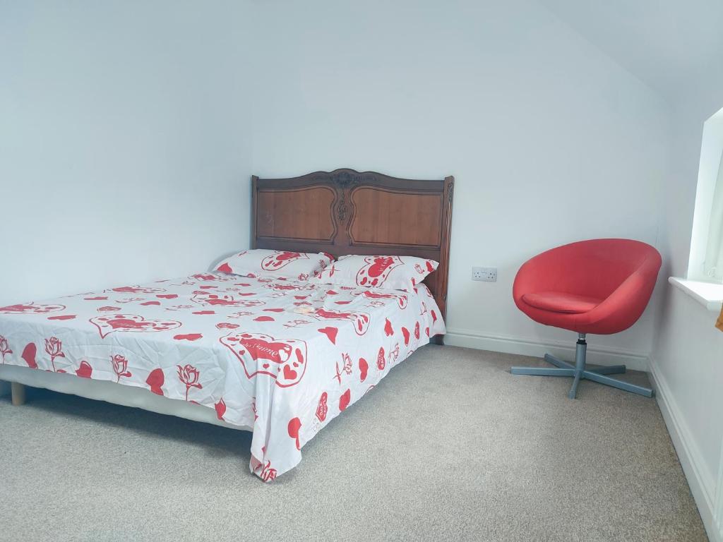 莱斯特Madif Ensuite的一间卧室配有一张床和一张红色椅子