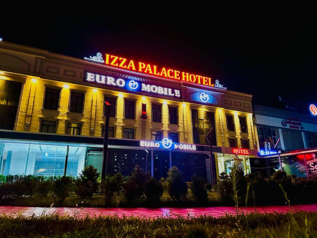 塔什干IZZA PALACE Hotel的一座晚上有比萨饼宫的建筑