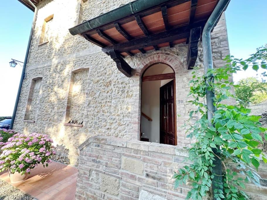 圣吉米纳诺Casale di Valle Mora的一座石头建筑,设有窗户和门