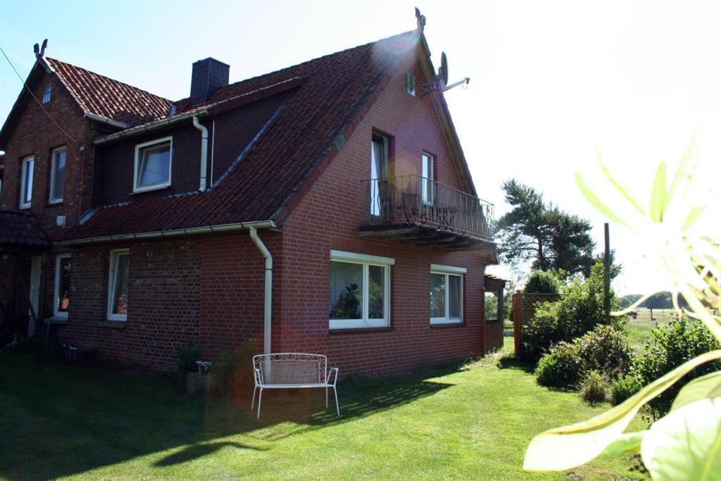 WinsenFerienwohnungen Bauernhof Beckmann的院子里有长凳的红砖房子