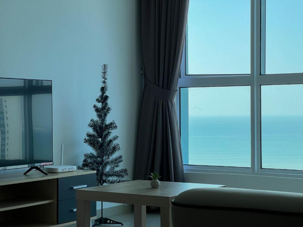 丹绒道光Seaview Private Master Bedroom in a Shared Unit的客厅配有圣诞树和桌子
