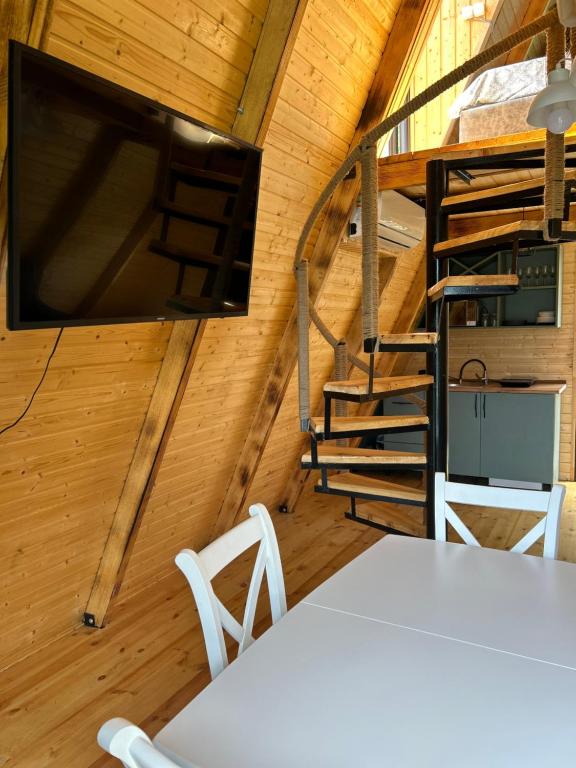 K'edaHillSide Cottage的小屋内配有电视和桌椅的房间