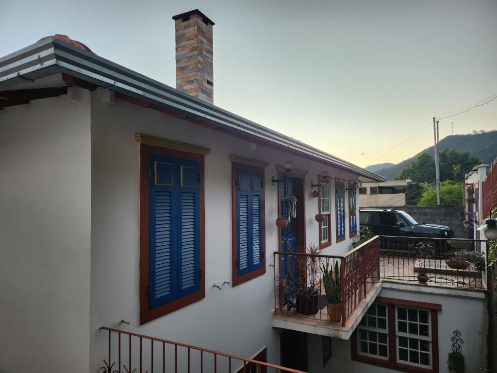 欧鲁普雷图Solar dos Reis - Apartamento Turmalina的白色的房子,设有蓝色百叶窗和阳台