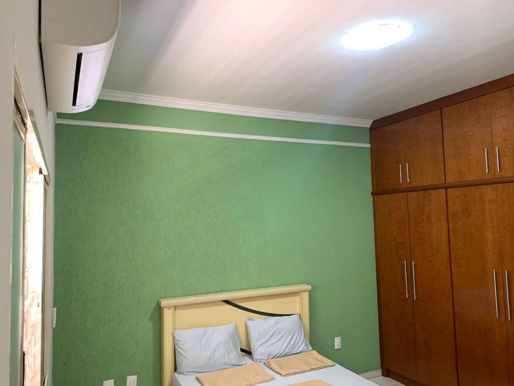 帕苏斯Hostel Home Passos的一间卧室设有绿色的墙壁和一张带白色枕头的床。