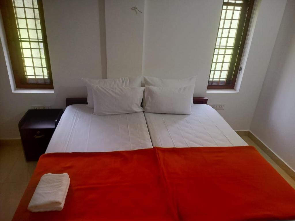 尼杜巴塞莱Grace Mary Residency的一间卧室配有一张带红色毯子的大床