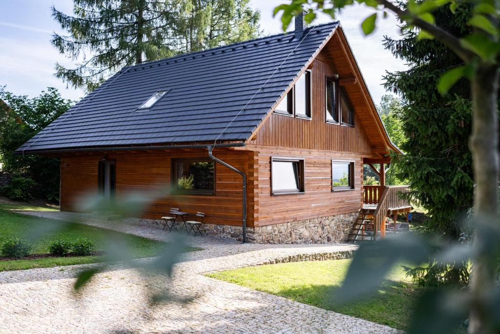 温佩尔克Moderní šumavská roubenka s výhledem na Boubín的小木屋设有黑色屋顶