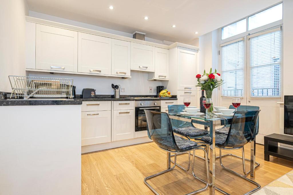 伦敦Turnmill Apartments的厨房配有玻璃桌和椅子