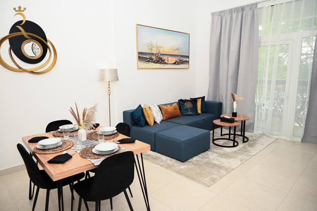阿布扎比1BR Oasis at Starry Yas Supernova Apartment的客厅配有蓝色的沙发和桌子