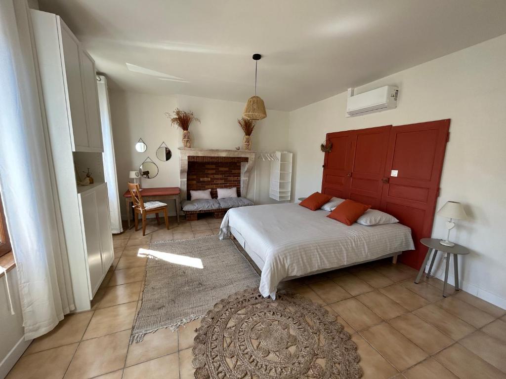 RadonvilliersL'OREE DES LACS, Maison de village tout confort的一间卧室配有一张床和一个壁炉