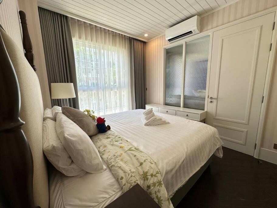 纳仲天Grand Florida Beach Waterpark Condo Resort的卧室配有白色的床和窗户