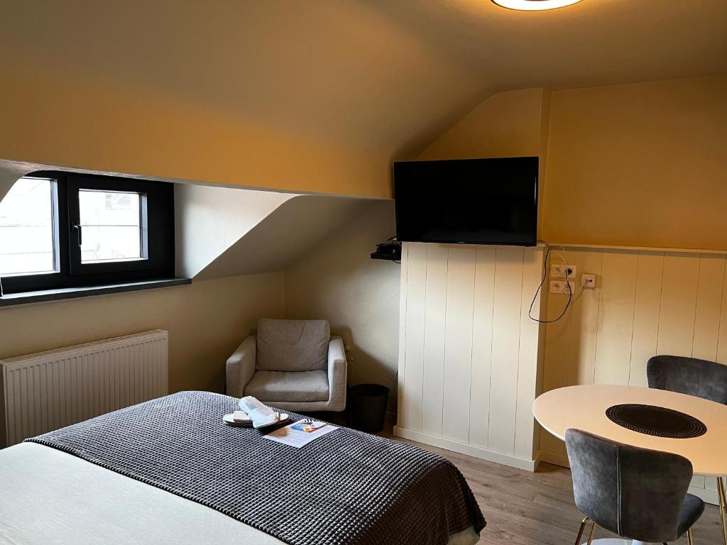鲁汶Escape in Leuven - Self check in的卧室配有1张床、1张桌子和1把椅子