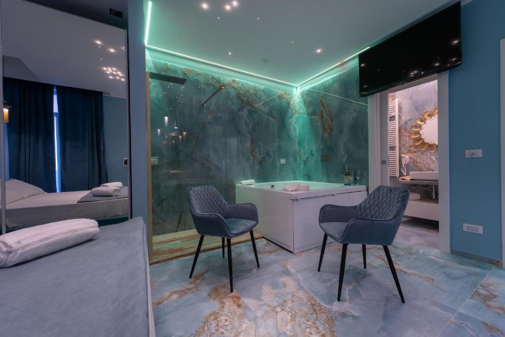 加利波利Suite Acquamarina Relais Stapane的一间带两把椅子和浴缸的浴室