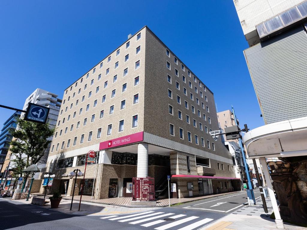 静冈Hotel Wing International Shizuoka的一条有人行道的城市街道上高大的建筑