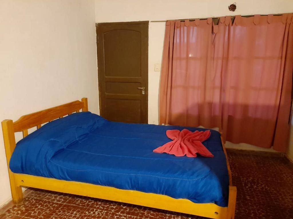 圣奥古斯汀镇Fatme Hotel的一间卧室配有一张蓝色的床,上面有红花