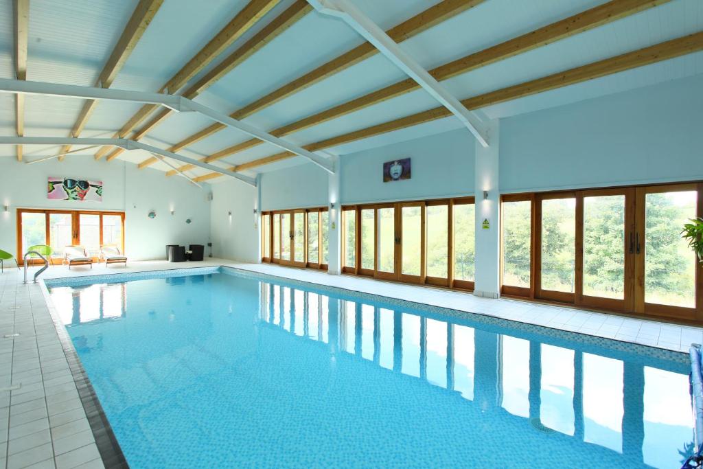 阿什伯恩Woodshed Cottage的一个带天花板和窗户的大型游泳池
