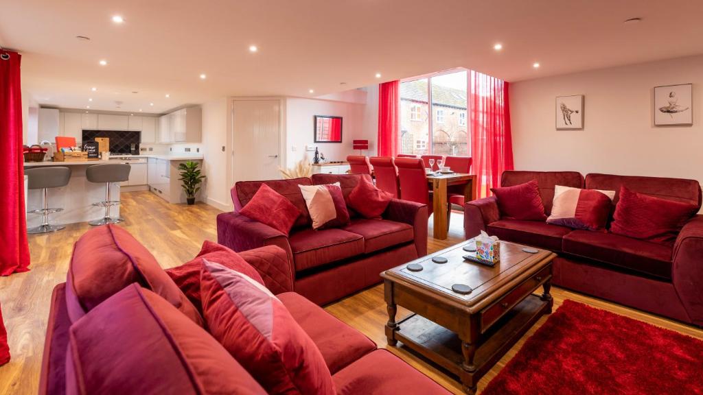 登比Cariad - Spacious 3 bed, group getaway Luxury Cottage with Private Hot Tub的客厅配有红色的沙发和桌子