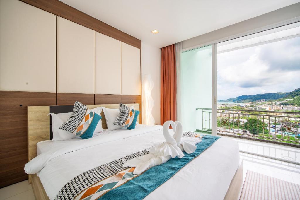 芭东海滩patong villa2：四卧泳池别墅/两个海景房/近班赞酒吧街的一间卧室设有一张大床和大窗户