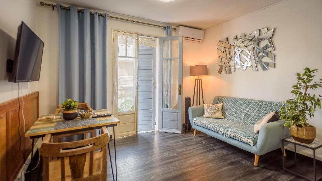 圣丹尼斯1A - Chambres et Appartements au calme - Centre St Denis - Barachois的客厅配有蓝色的沙发和电视