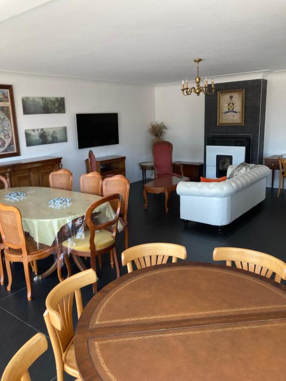 卢尔德La Villa sur le toit的客厅配有桌椅和沙发