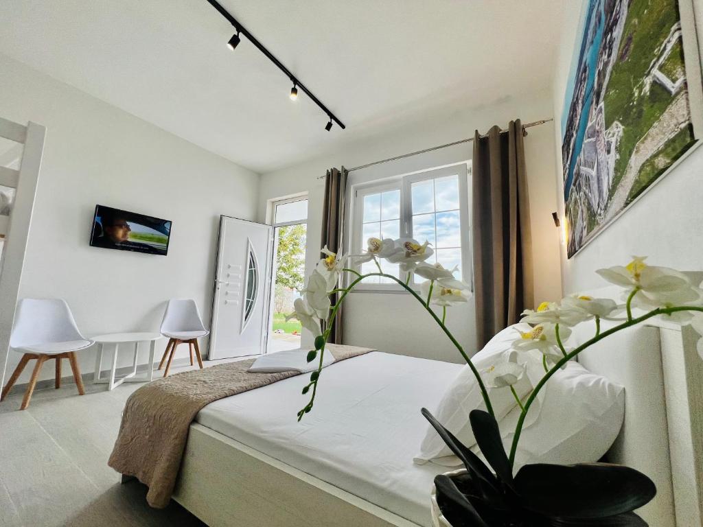 ŠirokaIart Residence的一间卧室配有床和白色花瓶