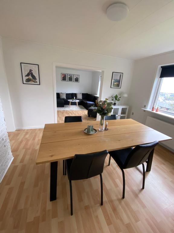 托尔斯港Apartment in the center of Tórshavn, free parking.的客厅配有一张木桌和椅子