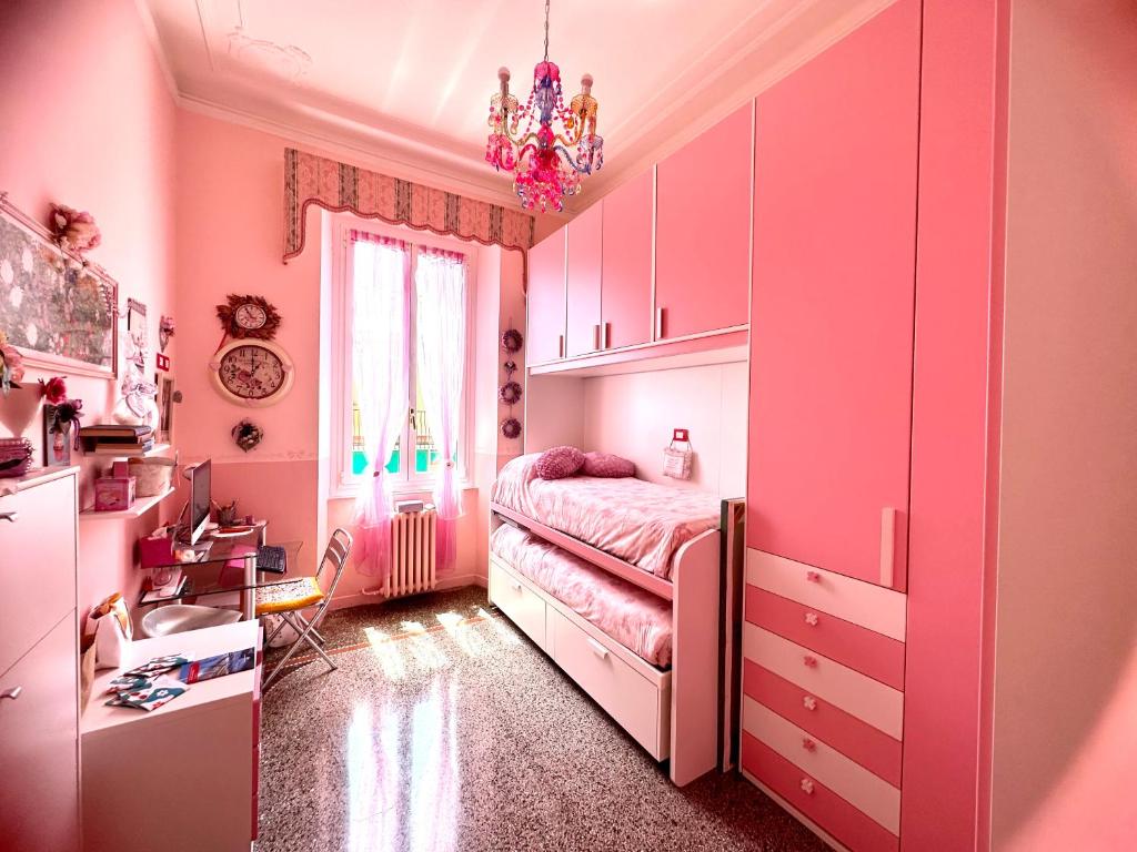 圣玛格丽塔-利古雷Notti magiche a Santa Margherita ligure的粉红色的卧室配有一张床和吊灯