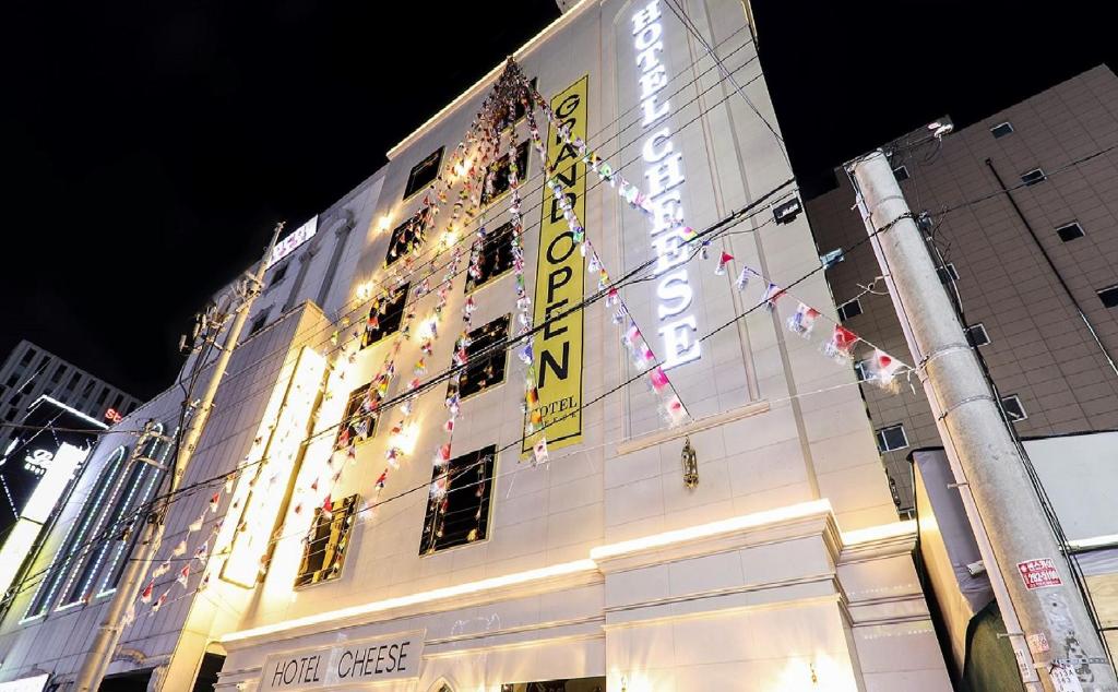 蔚山Hotel Cheese Ulsan Samsan的建筑物的侧面有灯光标志