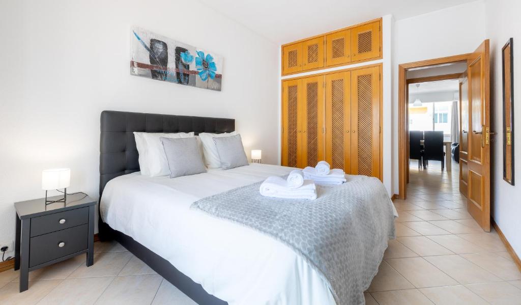 奎特里拉Sea-Front near Vilamoura - with AC, WiFi, Netflix的一间卧室配有一张大床和毛巾