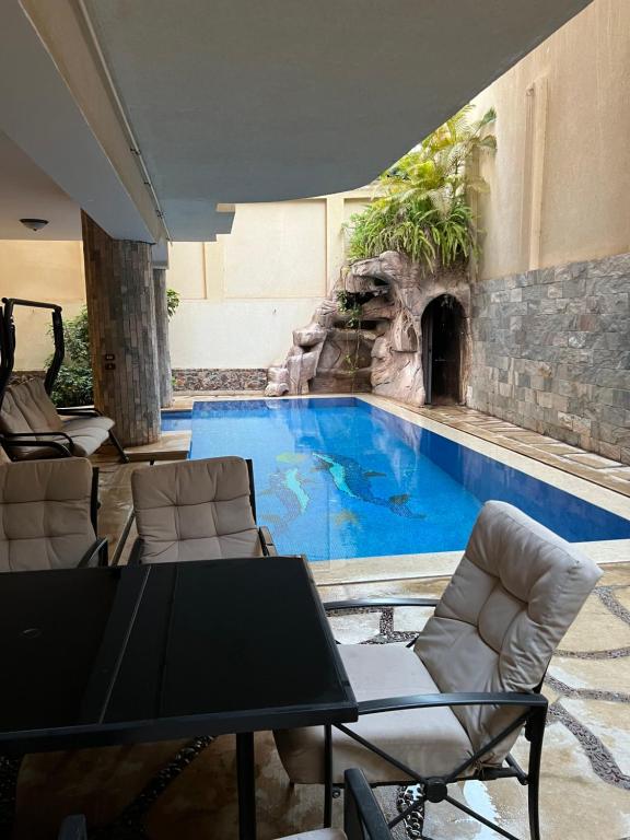 开罗The GlassHouse Pool的游泳池旁带岩石墙的大型游泳池