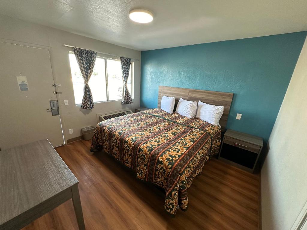 乔普林Super 7 inn的一间卧室设有一张床和蓝色的墙壁